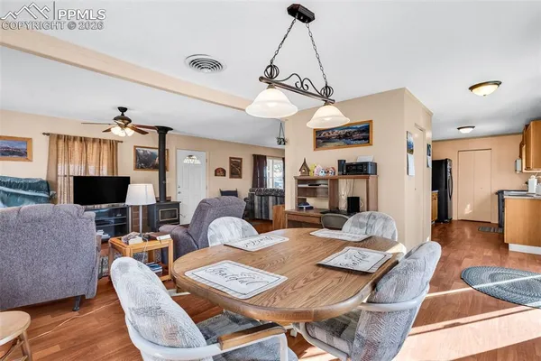 a living room with furniture a dining table and a chandelier