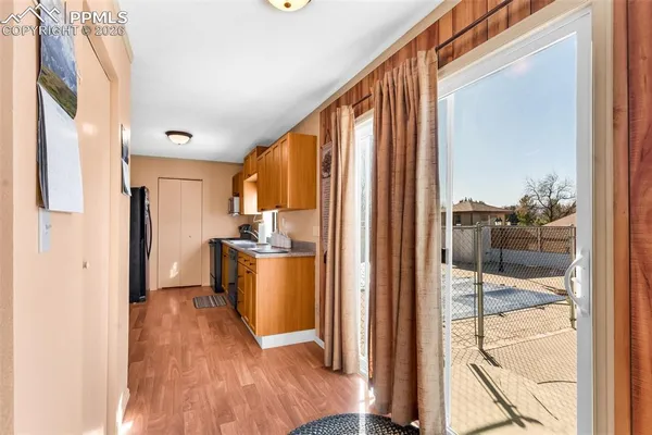 a kitchen with a refrigerator and a wooden floor
