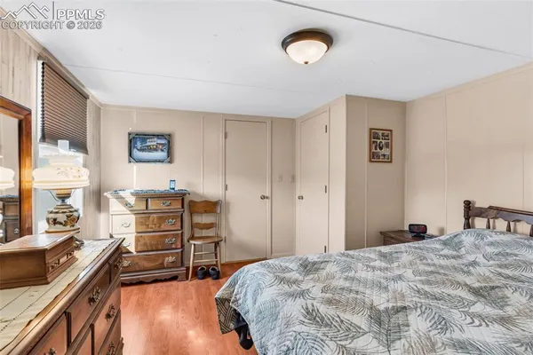 a bedroom with a bed and a dresser next to a window
