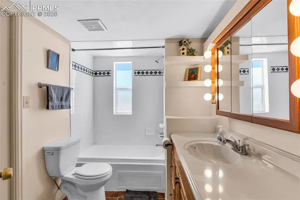 a bathroom with a tub toilet sink and mirror