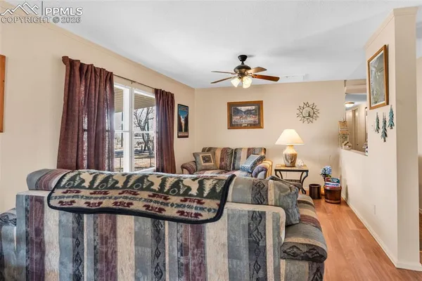 a living room with furniture a large window and dresser