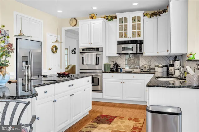 a kitchen with stainless steel appliances granite countertop a refrigerator sink and cabinets