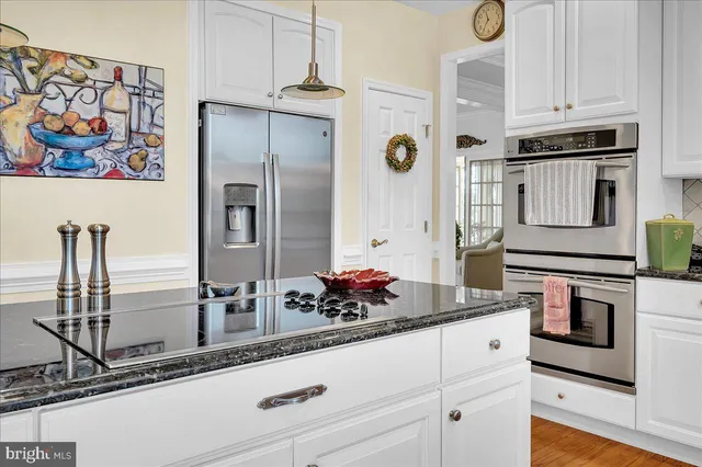 a kitchen with stainless steel appliances granite countertop a refrigerator and a stove