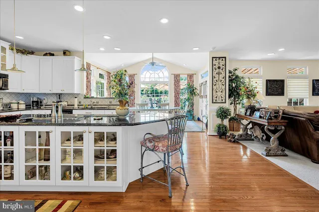a kitchen with stainless steel appliances granite countertop a stove and a view of living room