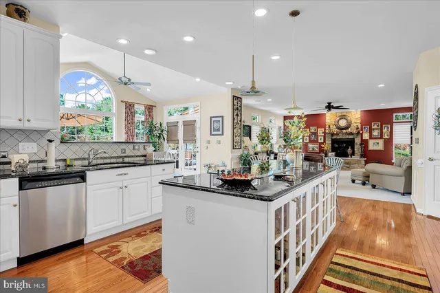 a kitchen with stainless steel appliances kitchen island granite countertop a sink and cabinets