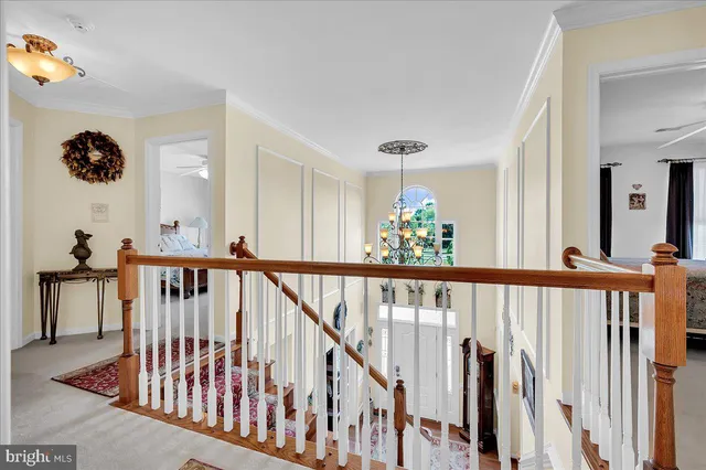 a view of staircase with railing and a chandelier
