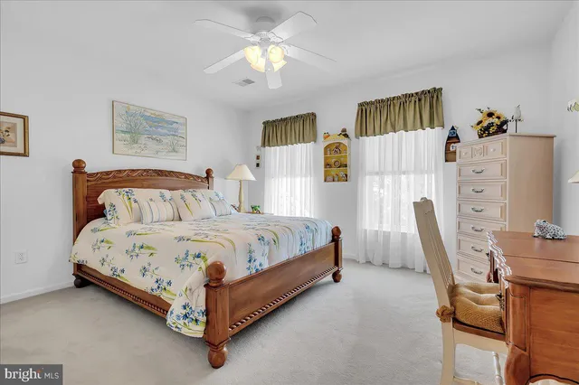 a bedroom with a bed a computer on desk and a dresser