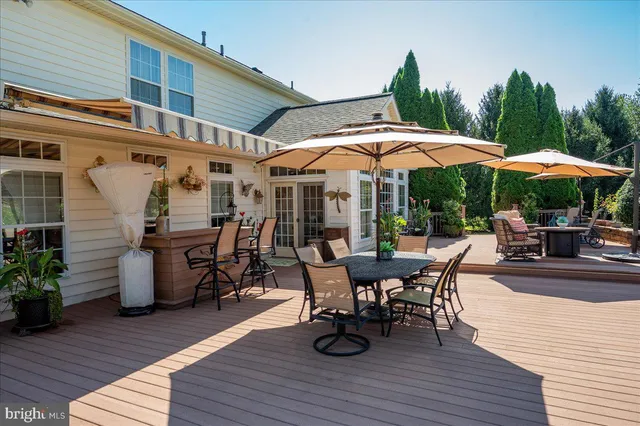 a view of a roof deck with table and chairs under an umbrella with wooden floor