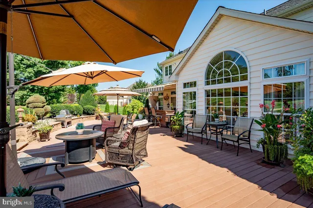 a view of a patio with couches table and chairs under an umbrella