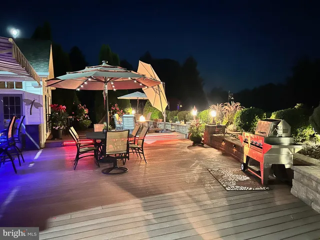 a view of a patio with dining table and chairs under an umbrella with a patio