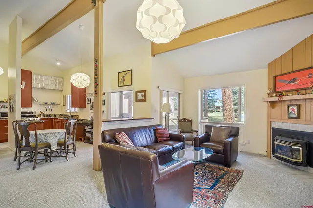 a living room with fireplace furniture and a large window