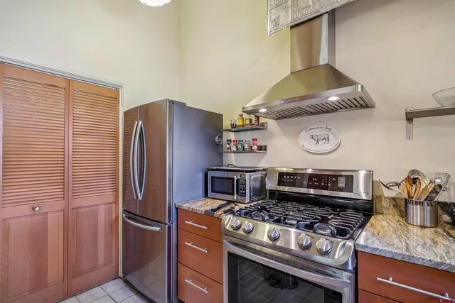 a kitchen with stainless steel appliances granite countertop a stove and a refrigerator