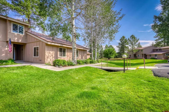 a view of a house with a yard and a tree