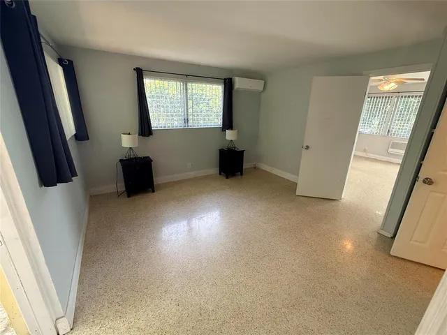 a view of an empty room with a fireplace and a window