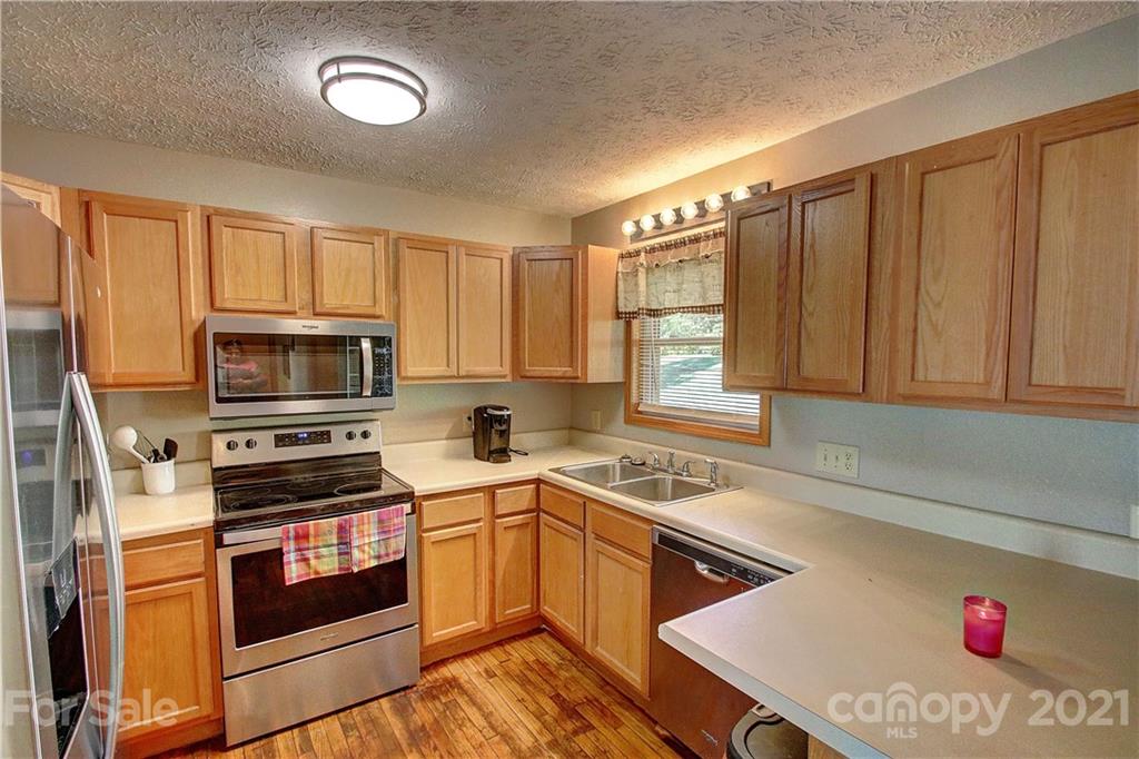 49 Sovereign Circle Clyde, NC 28721 - Photo 11 of 23 a kitchen with stainless steel appliances granite countertop a stove a sink dishwasher and a refrigerator