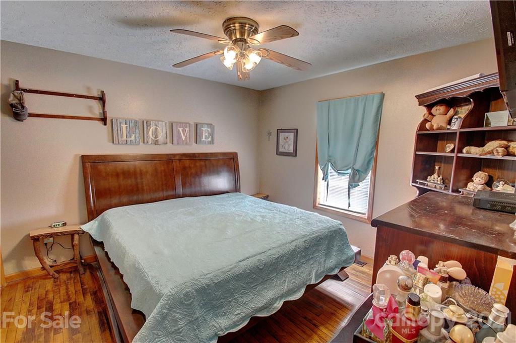 49 Sovereign Circle Clyde, NC 28721 - Photo 14 of 23 a bedroom with a bed and a chandelier