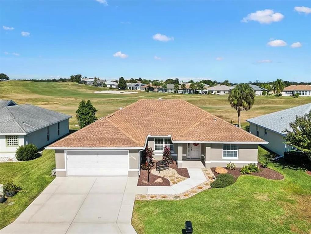 an aerial view of a house with big yard and large trees