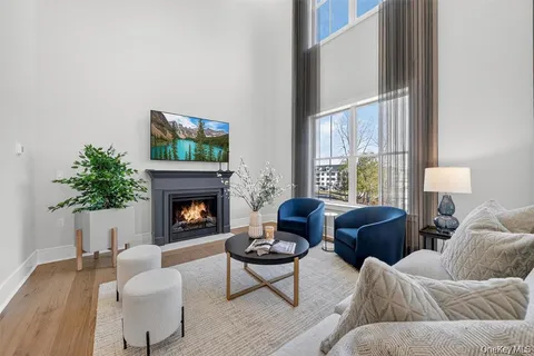 a living room with furniture a fireplace and a large window