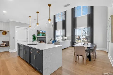 a large kitchen with stainless steel appliances a table chairs and a view of living room