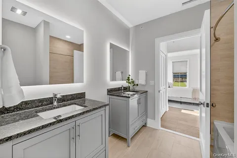 a bathroom with a granite countertop sink and a mirror