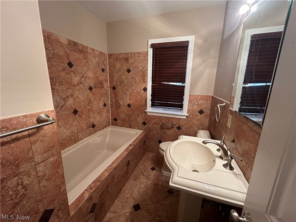 13537 Cedar Road Cleveland, OH 44118 - Photo 7 of 30 Bathroom with tiled shower / bath combo, tile flooring, toilet, and tile walls