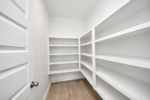 an empty room with a hardwood and windows