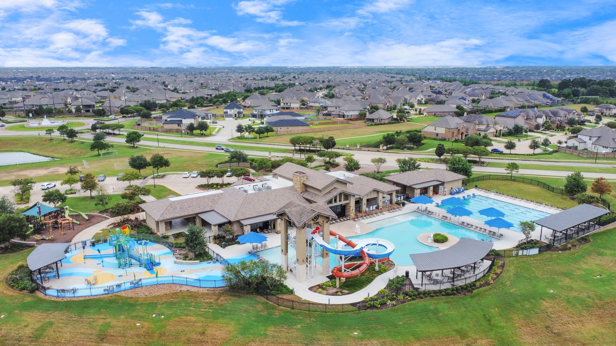 28603 Crowley Court Katy, TX 77494 - Photo 46 of 50 A vibrant community center with a large pool, water slides, and a splash pad, set in a well-maintained neighborhood. There are ample green spaces and playgrounds, offering a fun environment. Perfect for those seeking an active, community-oriented lifestyle.