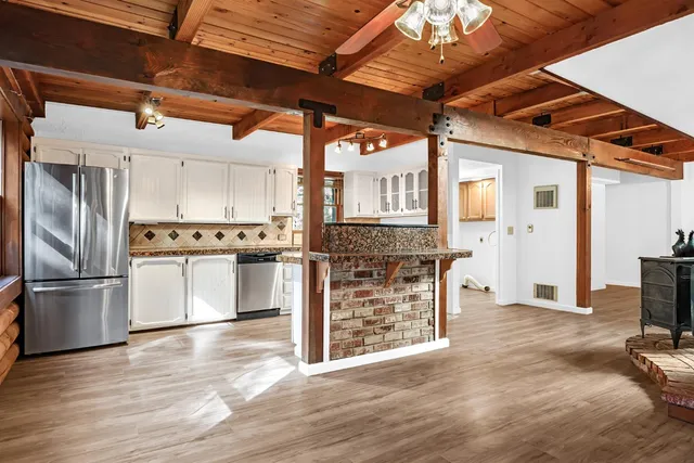 a kitchen with stainless steel appliances granite countertop a refrigerator and a stove top oven