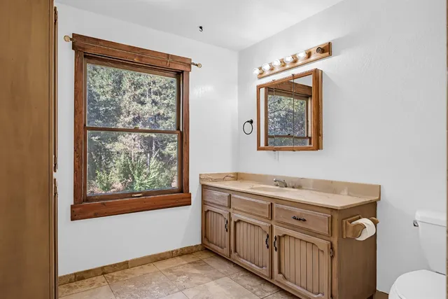 a bathroom with a sink mirror vanity and a toilet