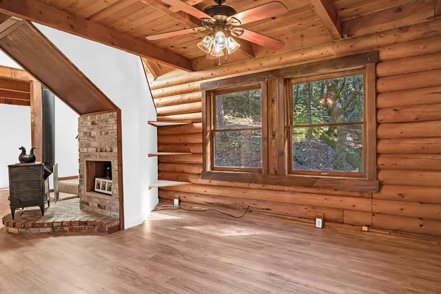 a view of a livingroom with wooden floor and a ceiling fan