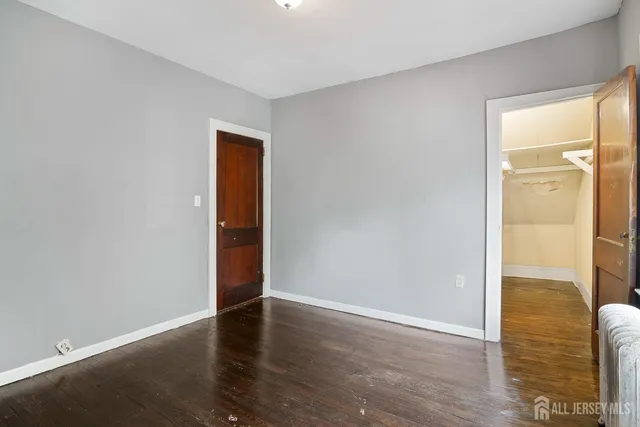 an empty room with wooden floor and door