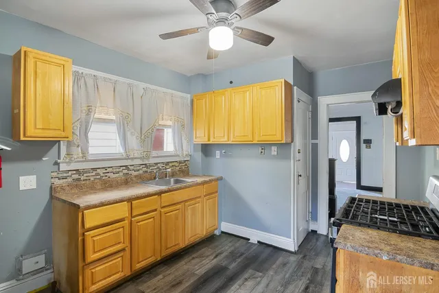 a kitchen with a stove a sink and a window