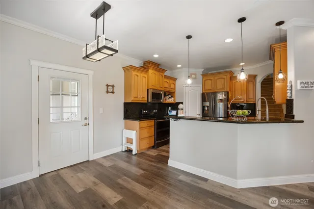 a view of a kitchen with granite countertop stainless steel appliances and wooden floor