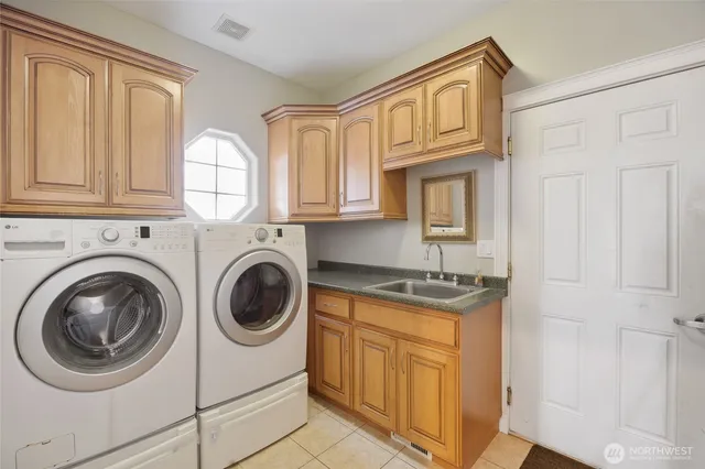 a utility room with sink dryer and washer