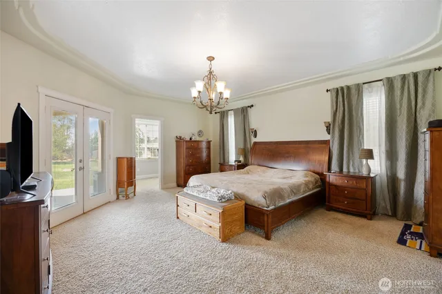 a spacious bedroom with a bed and a chandelier