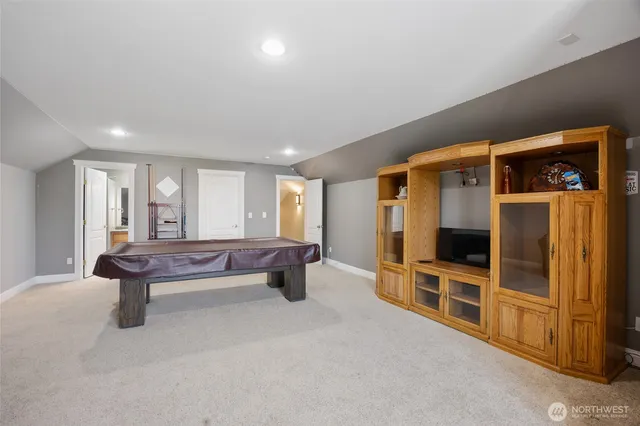 a living room with furniture a flat screen tv and floor to ceiling window