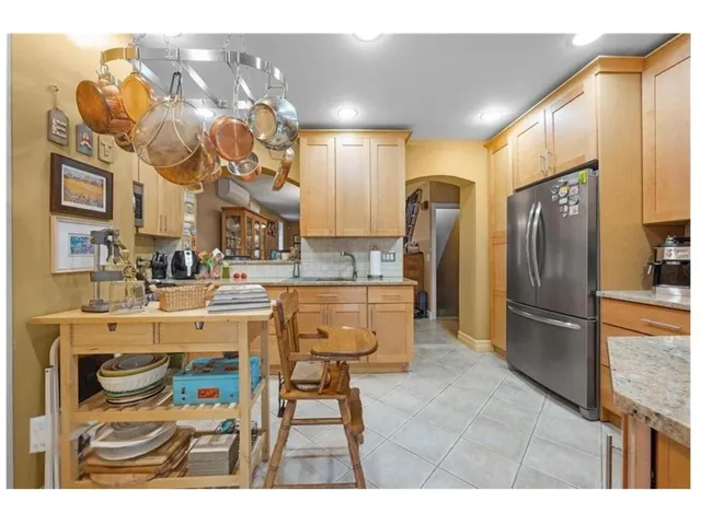 a kitchen with stainless steel appliances kitchen island granite countertop a refrigerator and a stove