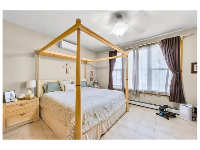 a bedroom with a bed and a large window