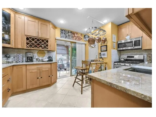 a kitchen with stainless steel appliances kitchen island granite countertop a sink and cabinets