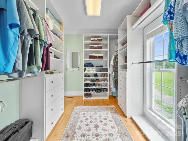 a view of walk in closet with clothes and shoes