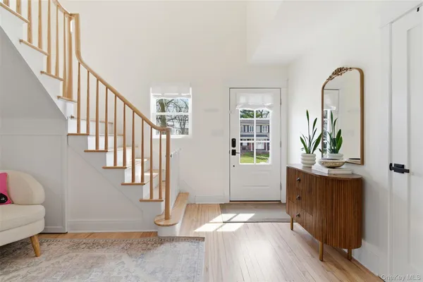 a view of entryway and hall with wooden floor