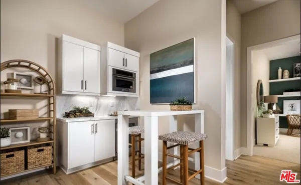 a living room with stainless steel appliances furniture and a flat screen tv