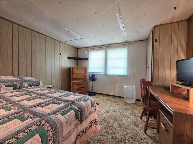 a view of a swimming pool with lawn chairs and a big yard