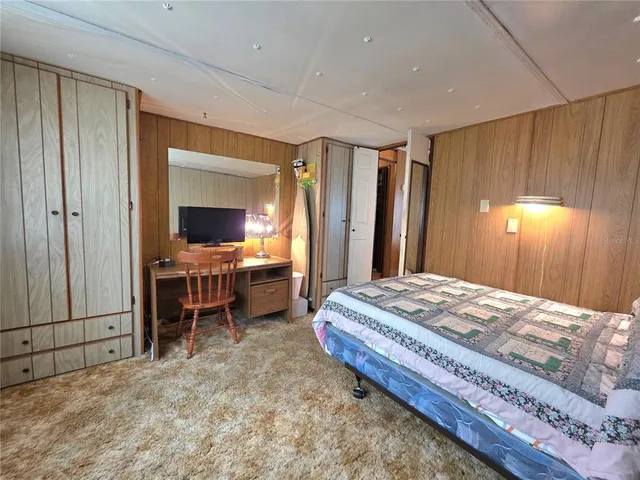 a view of a house with a big yard and large trees