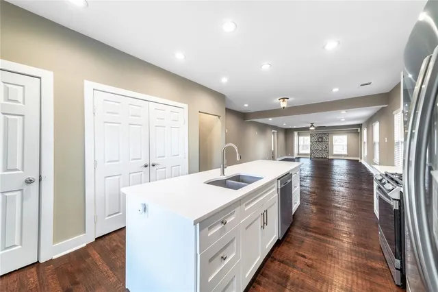 a kitchen with a sink and wooden floor