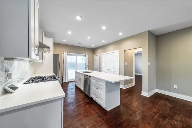 a large kitchen with a center island and stainless steel appliances