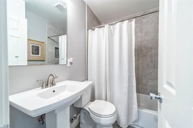a bathroom with a sink a toilet and shower curtain