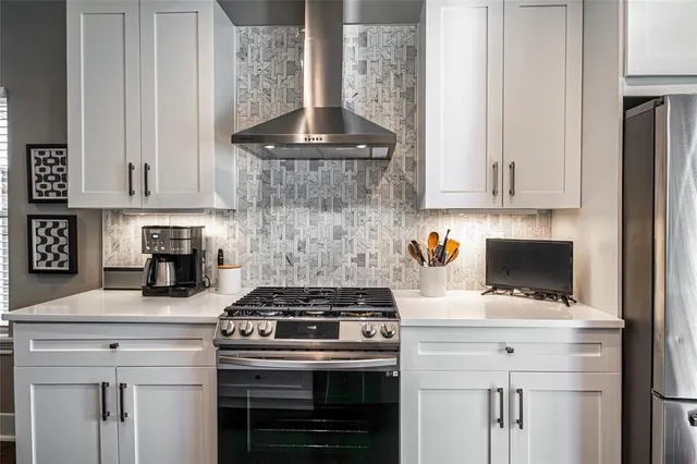 a kitchen with a stove and white cabinets