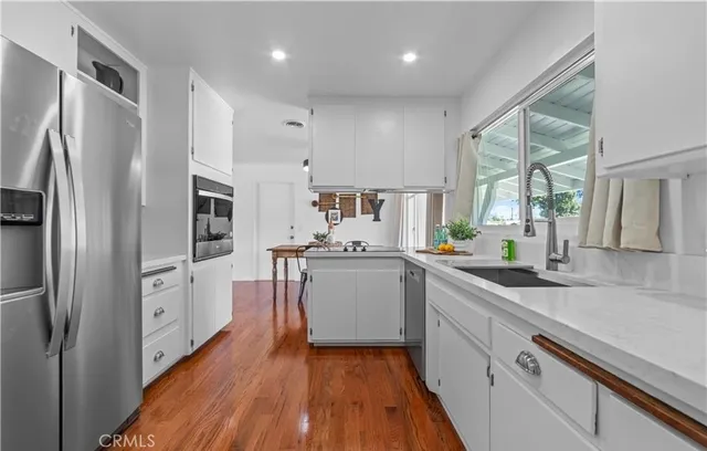a kitchen with white cabinets and white appliances