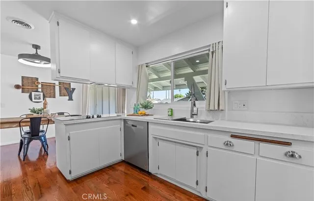 a kitchen with a sink a window and stainless steel appliances